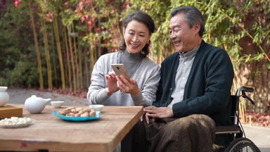 老年夫妇在庭院使用手机